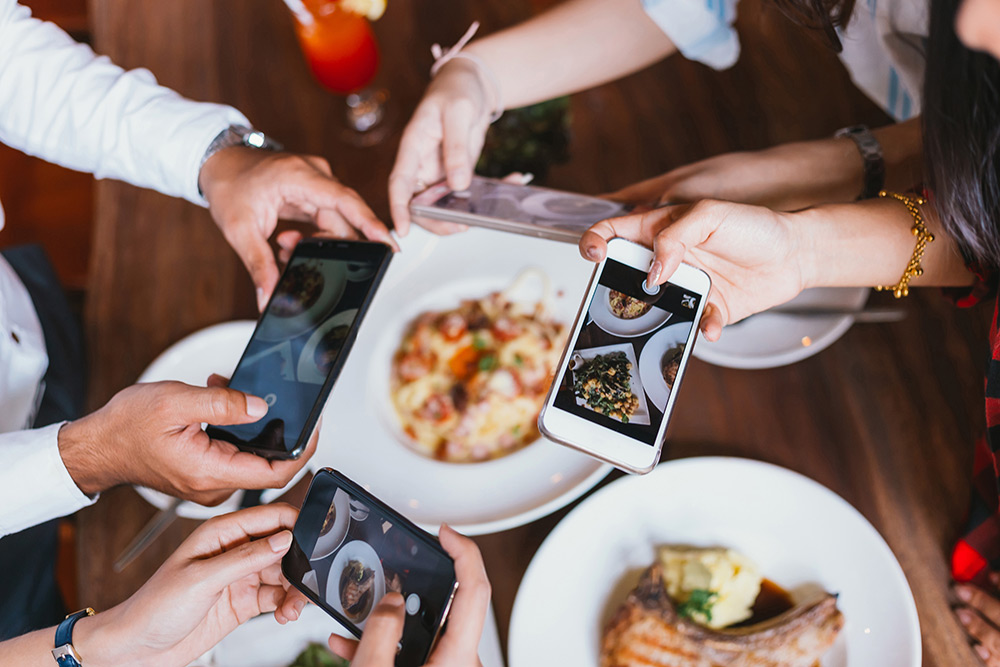 Friends taking photos of food with their phones